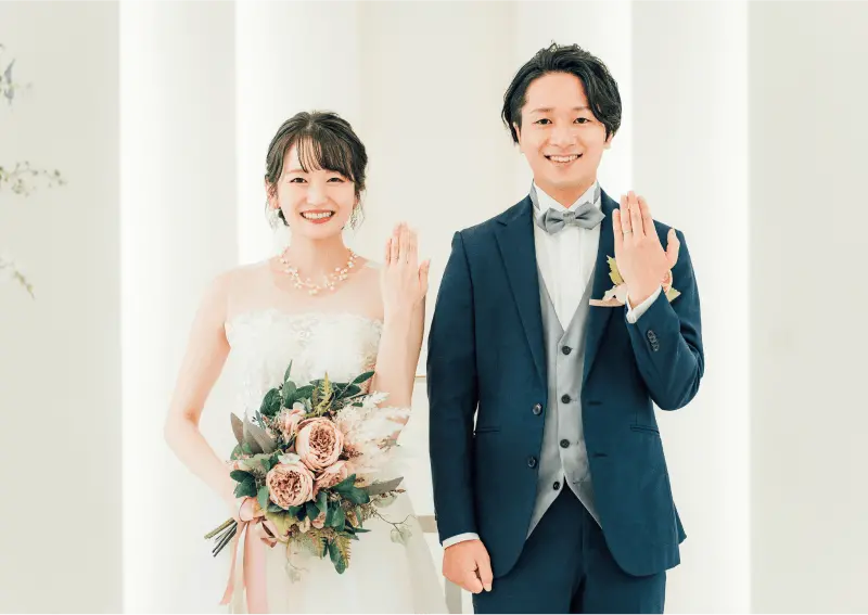 結婚式場で指輪を見せる新郎新婦